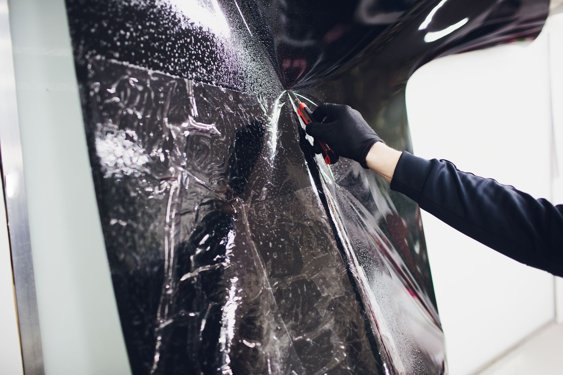 Applying tinting foil on car window in garage